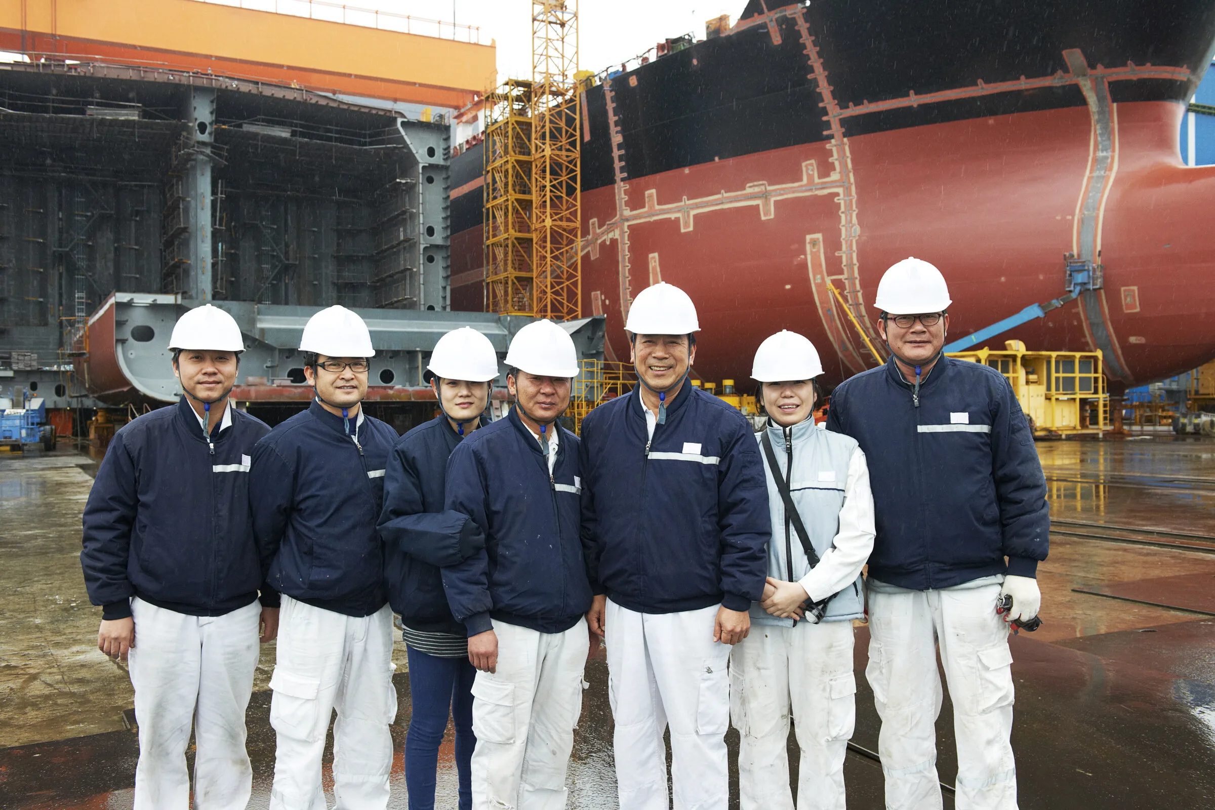 Shipyard project team standing together beside an offshore vessel