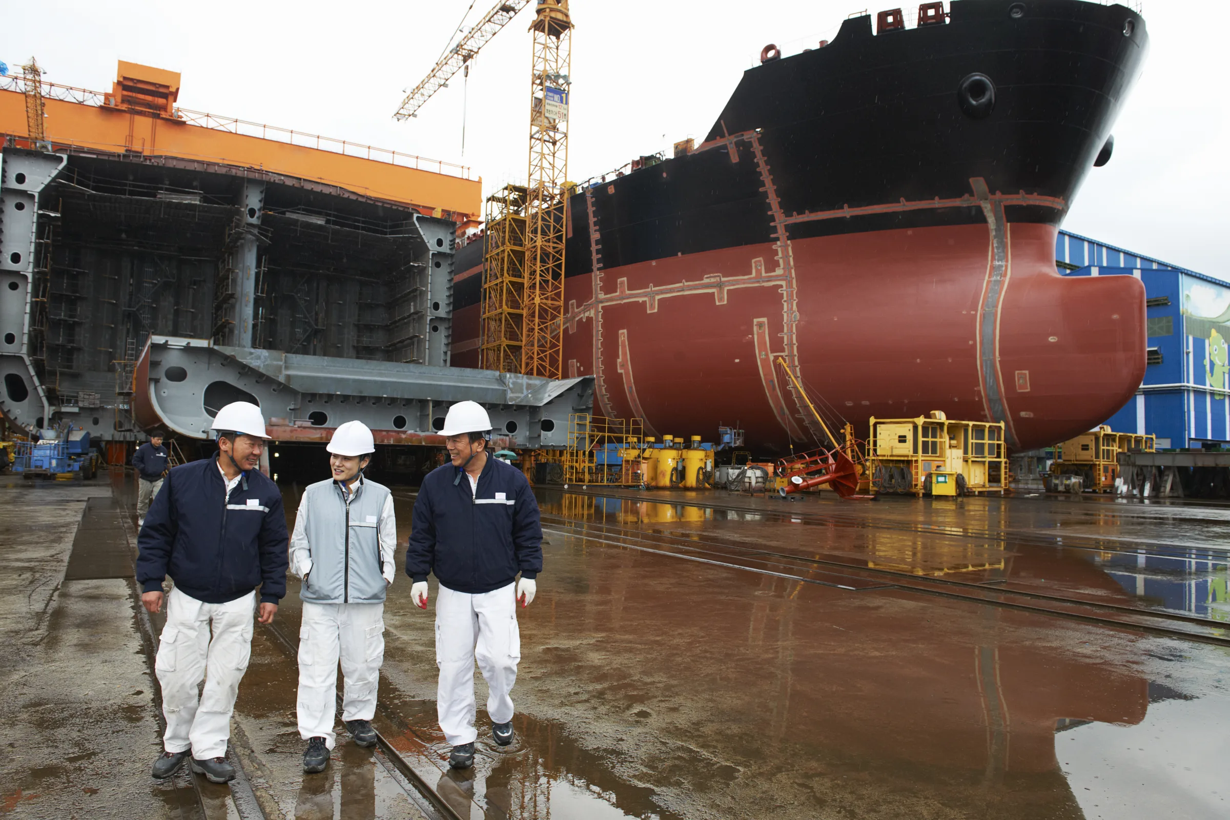 Shipyard workers walking together through a dry dock