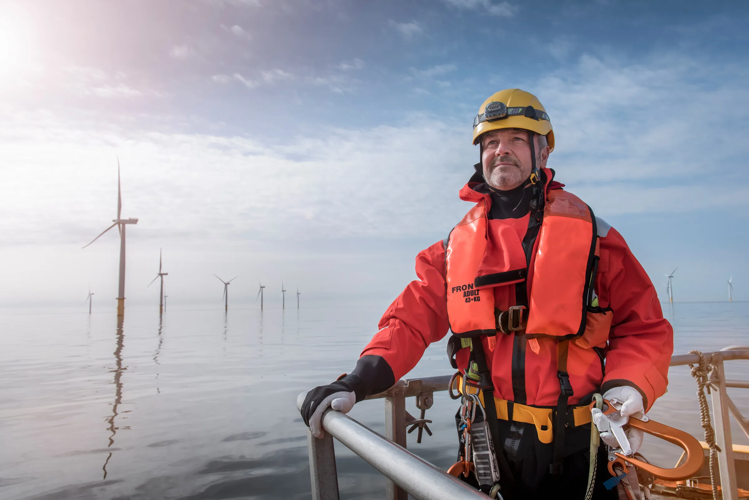 Worker on an offshore platform near wind turbines